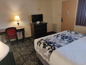 a hotel room with a bed and a desk and a television at Skyline Motor Inn in Cody