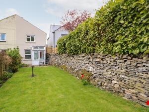 un muro di pietra di fronte a una casa di Daisy Cottage a Leyburn