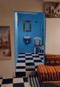 bagno blu con lavandino e sedia di Dar Beldi a Marrakech