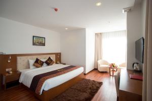 um quarto de hotel com uma cama e uma televisão em Centre Hotel em Da Nang