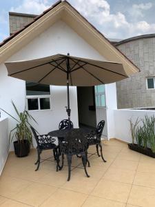 a table and chairs under an umbrella on a patio at Hotel La Condesa in Huasca de Ocampo