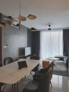 ein Zimmer mit einem Tisch und Stühlen sowie einem Laptop darauf in der Unterkunft Rica residence in Kuala Lumpur