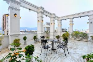 a patio with a table and chairs on a balcony at Centre Hotel in Da Nang