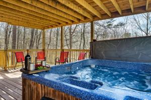 a hot tub on a deck with red chairs at Gnoming Around in Gatlinburg