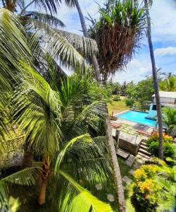 a view of a resort with a pool and palm trees at Traveller's Home Hotel in Tissamaharama