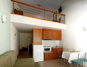 cocina y sala de estar con nevera blanca en Zouzoulas Filoxenia - Koralia Apartments, en Milina