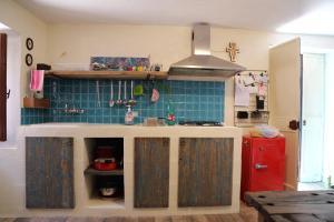 uma cozinha com azulejos azuis e um frigorífico vermelho em Casetta Nonna Augusta (Spello 9 km-Assisi 12 km) em Spello