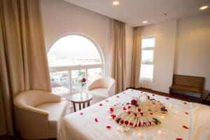 a hotel room with a bed with a flower arrangement on it at Centre Hotel in Da Nang