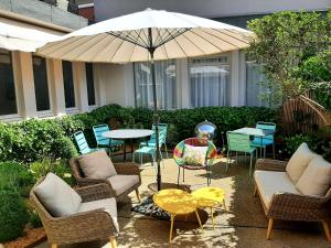 patio z krzesłami i stołem z parasolem w obiekcie Cit'Hotel Grand Hotel L'Etape w mieście Saint-Flour