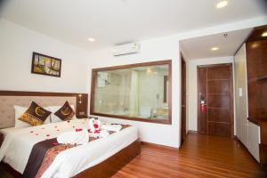 a bedroom with a bed with a large mirror at Centre Hotel in Danang