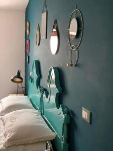 a blue bedroom with a bed and mirrors on the wall at Casetta Nonna Augusta (Spello 9 km-Assisi 12 km) in Spello