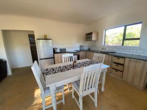 a kitchen with a table with chairs and a refrigerator at Vlakkieskraal Farmstay - BushBaby House in Bela-Bela
