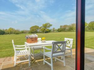 a table and chairs on a patio with a view of a field at Down the Rabbit Hole in Bristol