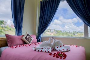1 dormitorio con cama rosa y ventana en Mây Trắng Villa, en Da Lat