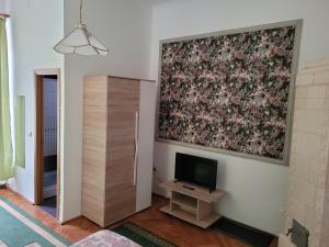 Una sala de estar con un televisor y un cuadro en la pared. en Casa Anda, en Sibiu