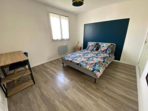 1 dormitorio con 1 cama con cabecero azul en Maison joliment rénovée à 5 minutes du futuroscope, en Chasseneuil-du-Poitou