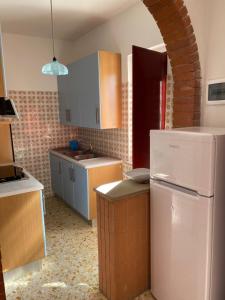 eine Küche mit einem weißen Kühlschrank und einer Ziegelwand in der Unterkunft VILLA PINETA VISTA MARE in San Menaio