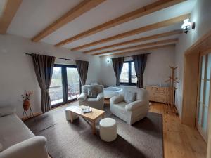 a living room with two chairs and a table at Casa Oaspeti Transfagarasan in Cârțișoara