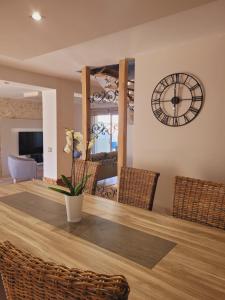 a dining room with a large clock on the wall at L'inattendu, jolie maison briarde avec jacuzzi in Chenoise