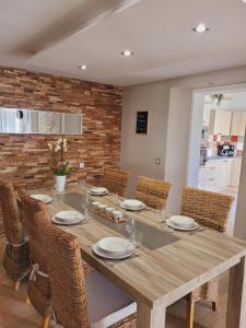 comedor con mesa de madera y sillas en L'inattendu, jolie maison briarde avec jacuzzi, en Chenoise