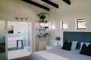 a bedroom with a bed and a bathroom with a sink at 9 Windsor House in Tokai