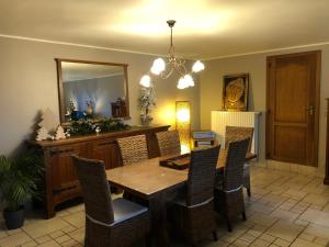 uma sala de jantar com uma mesa, cadeiras e um espelho em Au Coeur des Collines, Charmette em Ellezelles