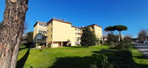 a large white building on a green lawn at Appartamento Sette Lecci in Lido di Camaiore