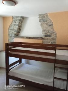 een stapelbed in een kamer met een stenen muur bij Agriturismo Ardissone Thomas in Diano San Pietro