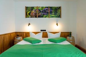 a bedroom with two beds with green and white pillows at Die GURKENSCHEUNE - Frühstückspension in Lübbenau