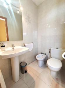 a bathroom with a sink and a toilet and a mirror at Hostal Neus in Alcalà de Xivert