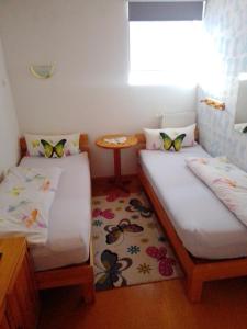 two beds in a small room with a table at Gästehaus Brunhilde in Wittenweier