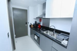uma cozinha com um lavatório e uma bancada em DAMAC MAISON PRIVE em Dubai