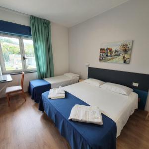 Cette chambre comprend 2 lits et une fenêtre. dans l'établissement Hotel Pixunte, à Policastro Bussentino