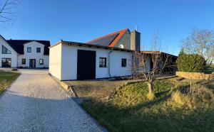 una casa blanca con una puerta negra y un árbol en schicke Wohnung im Grünen, en Dreiheide