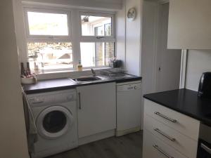 a kitchen with a washing machine and a sink at Number 10 in Cullipool