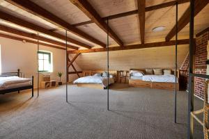 two beds in a room with wooden ceilings at Statek 85 in Mařenice