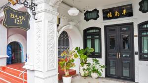 a building with black doors and potted plants at BAAN 125 STAY Phuket in Phuket