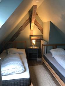 two beds in a room with a roof at L Atypik à L ancienne forge in Muhlbach-sur-Munster