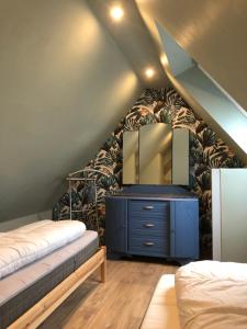 a bedroom with a bed and a dresser with a mirror at L Atypik à L ancienne forge in Muhlbach-sur-Munster
