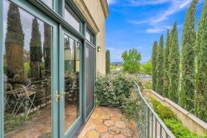 a balcony with sliding glass doors and trees at Cypress House & Studio, Walk to Healdsburg Plaza home in Healdsburg