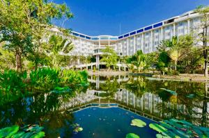 a building with a pond in front of it at Hermitage Hotel Korat-SHA in Nakhon Ratchasima