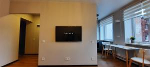 a living room with a flat screen tv on a wall at Teodora B. Apartament in Liepāja +10 photos