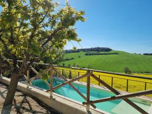 a wooden fence and a swimming pool next to a field at B&B Ceresà - Country House in Loreto