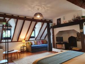 a bedroom with a blue couch in a room at Gîtes sur Le Causse de St CHELS, charme sport et détente in Saint-Chels