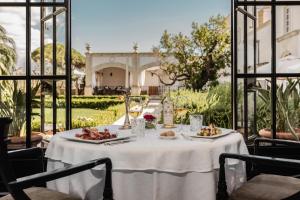 uma mesa branca com comida em cima em Tenuta Mosè Charming House&Relais Gallipoli em Gallipoli