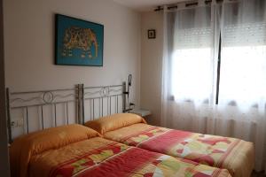 1 Schlafzimmer mit 2 Betten und einem Fenster in der Unterkunft La Tilar, apartamento con gran terraza a 3 km de la playa in Llanes