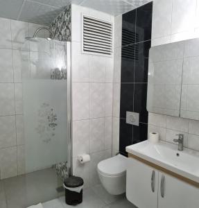 a white toilet sitting next to a bath tub in a bathroom at Sezgin Boutique Hotel in Kusadası