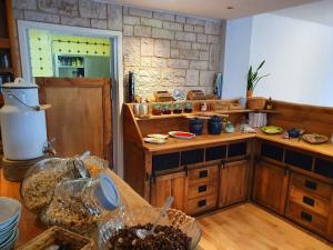 a kitchen with wooden counters and a stone wall at Die GURKENSCHEUNE - Frühstückspension in Lübbenau