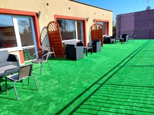 a patio with green grass and chairs on it at Belona in Stegna