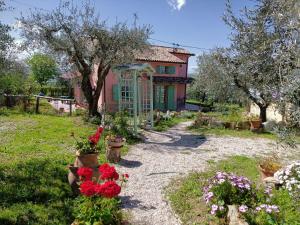 a house with a garden with flowers in front of it at Le Rondini in Montecosaro